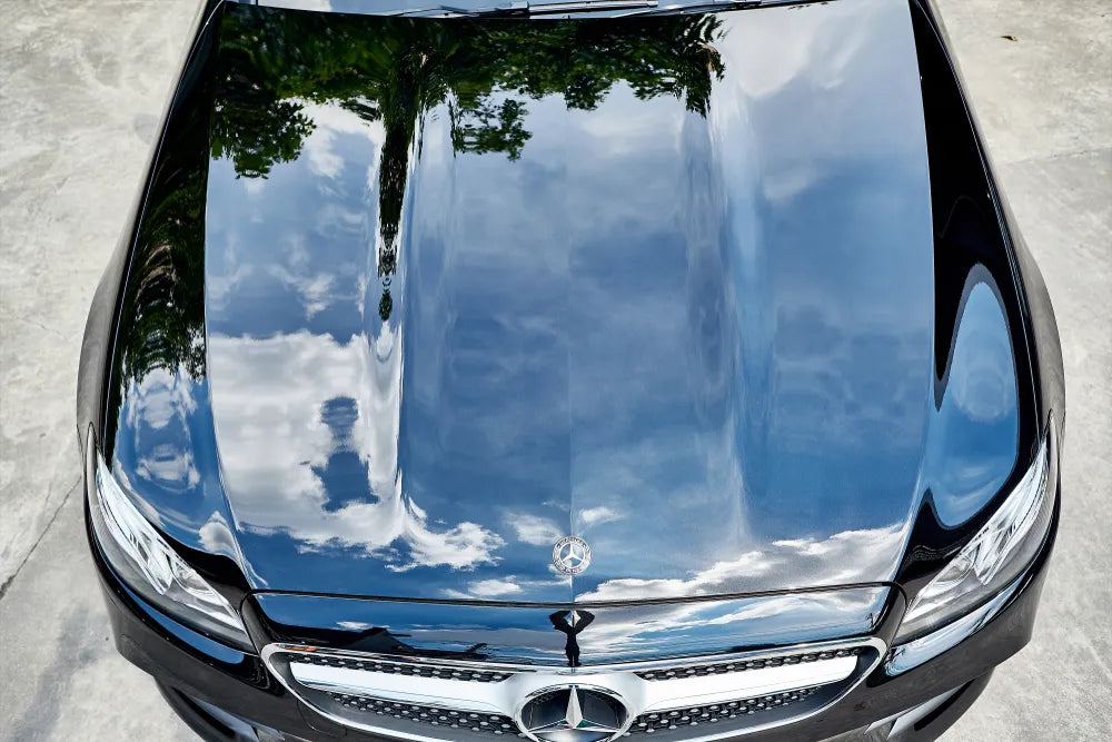 The Mercedes Benz E-Class Coupe with reflection of clear sky on hood after paint polishing & coating