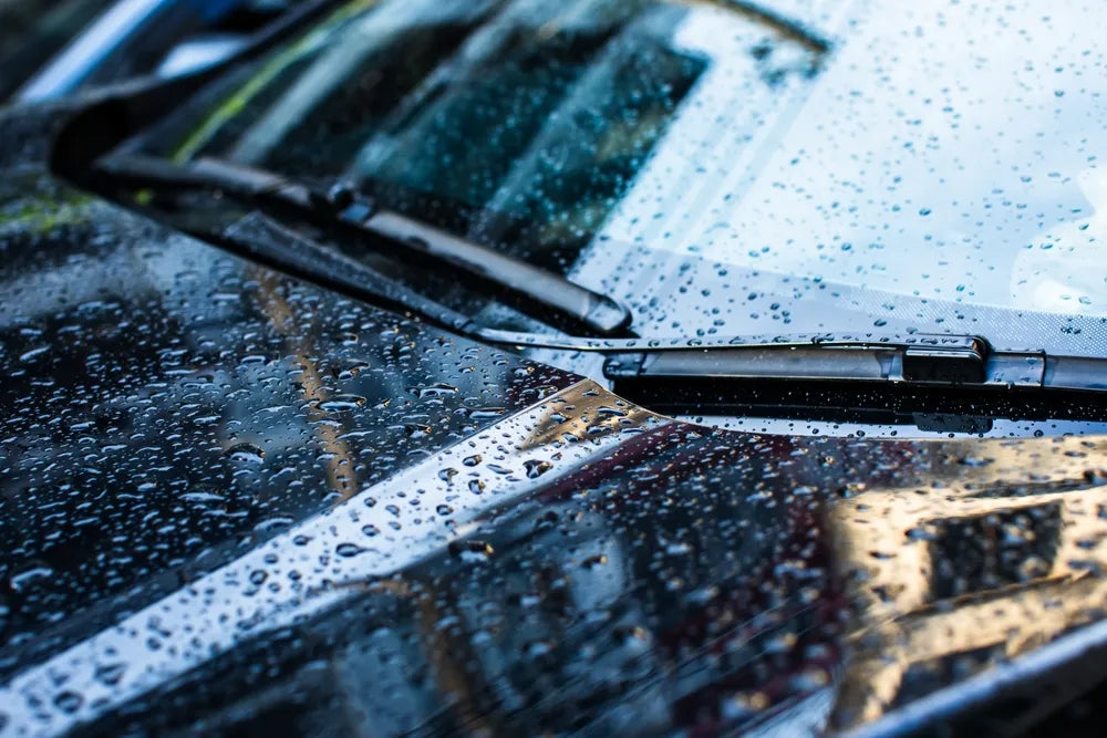 Selective focus to rain droplet with wiper on windshield.
