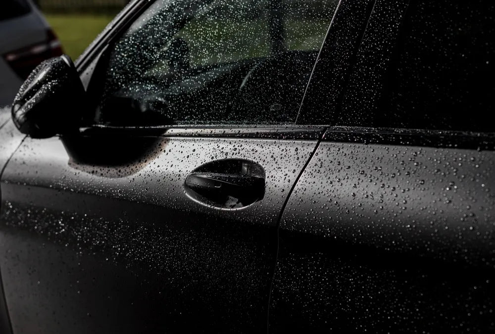 Close-up of a car panel with a custom textured aerosol spray paint finish being applied