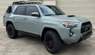 Lunar Rock Toyota 4Runner SUV with black roof rack and off-road tires